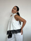 Top polera blanco halter asimétrico con detalle de encaje negro y amarras, diseño elegante para mujer
