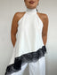 Top polera blanco halter asimétrico con detalle de encaje negro y amarras, diseño elegante para mujer